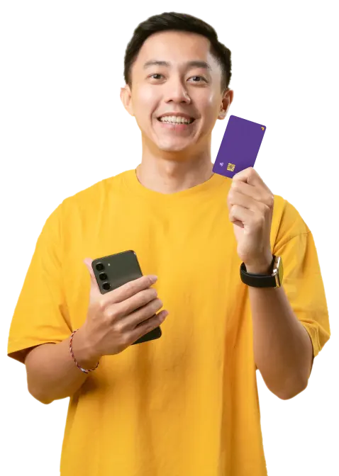 A smiling young man holding a phone in his right hand and a U Visa Prepaid Card in his left